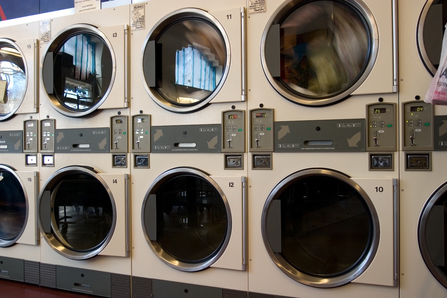 Immagine di una serie di asciugatrici in un tipico wash and dry, per descrivere il servizio di gestione di lavanderie a gettoni e pet wash di L'Orologio Societ&agrave; Cooperativa.