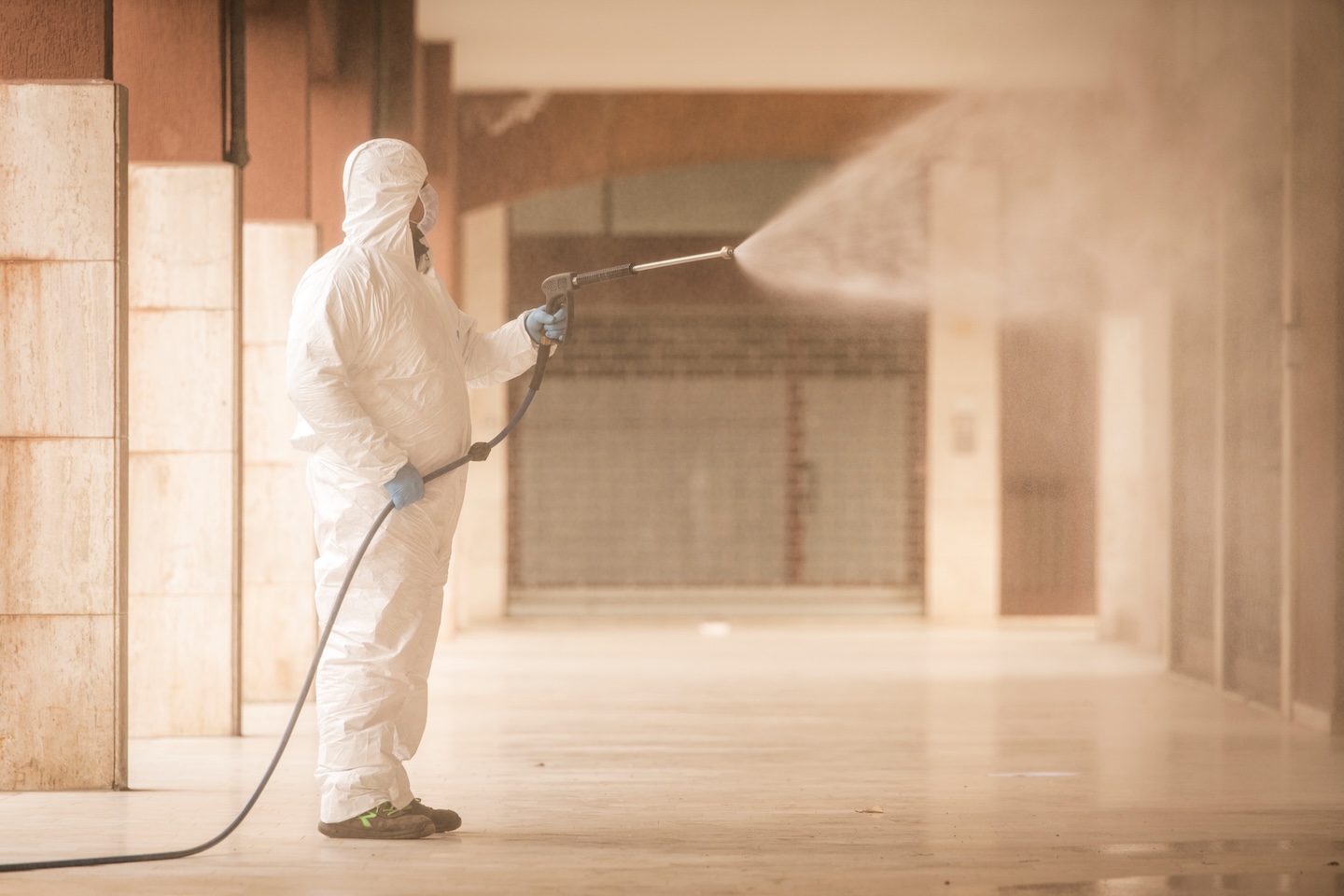 Immagine di un operatore specializzato nella sanificazione di un ambiente esterno, per descrivere il servizio di pulizia e sanificazione di L'Orologio Societ&agrave; Cooperativa.